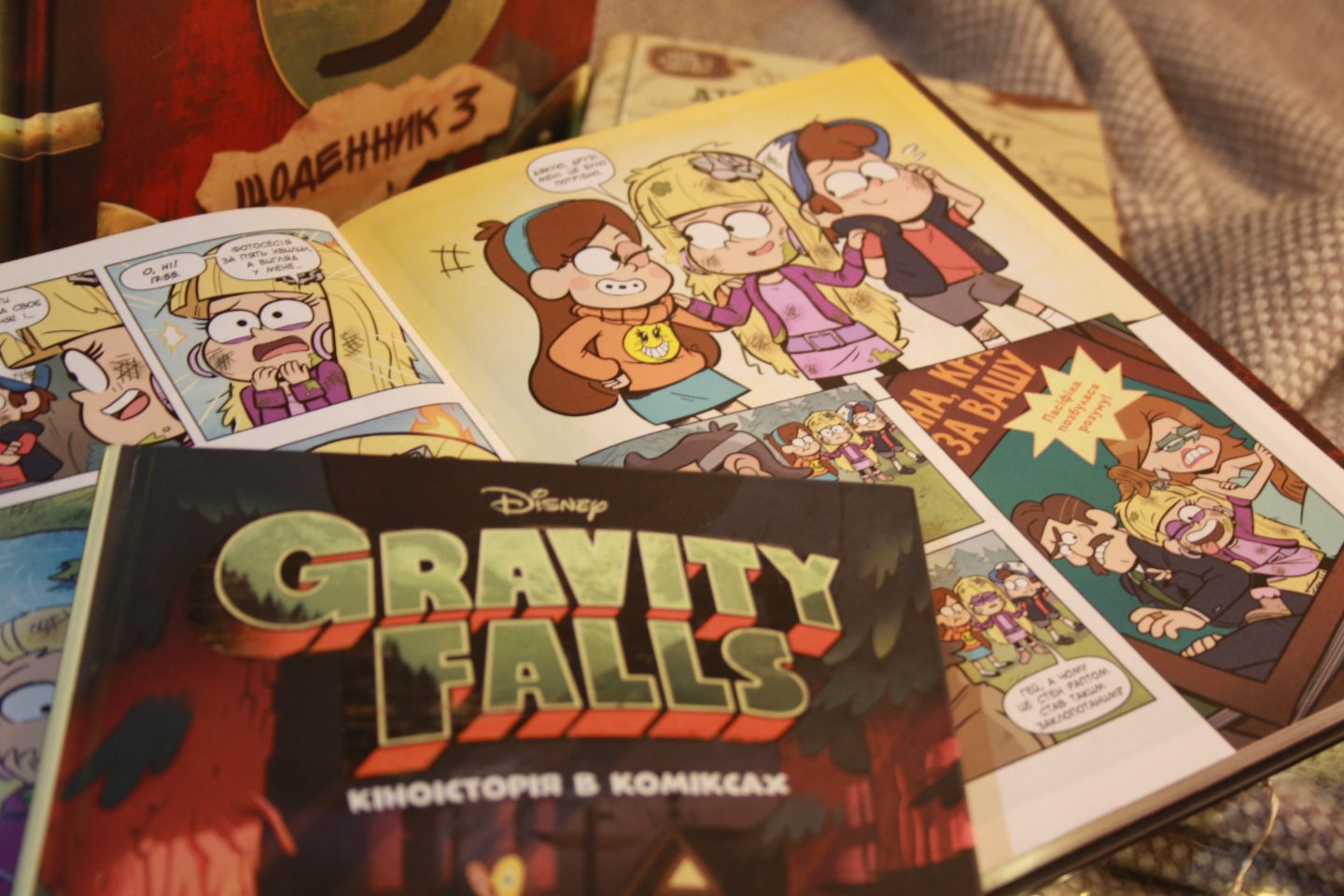 Gravity Falls comic books opened to illustrated pages